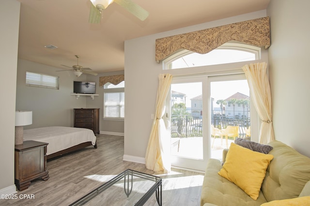 bedroom with wood finished floors, baseboards, visible vents, ceiling fan, and access to outside