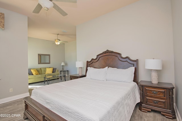 bedroom with ceiling fan, baseboards, and wood finished floors