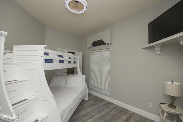 bedroom featuring baseboards and dark wood-type flooring