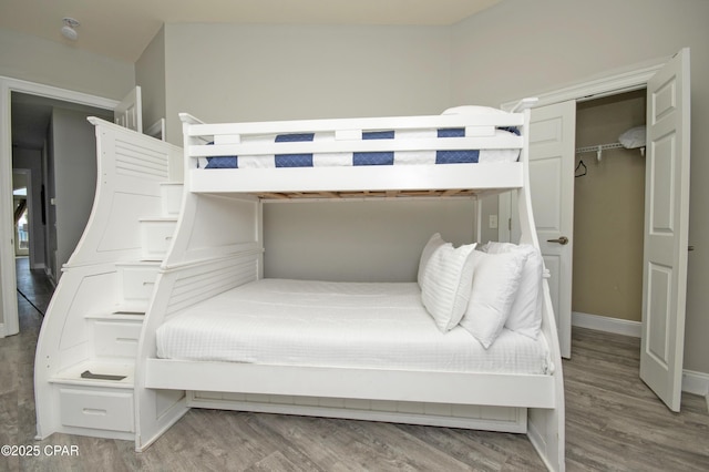 bedroom with a closet, baseboards, and wood finished floors