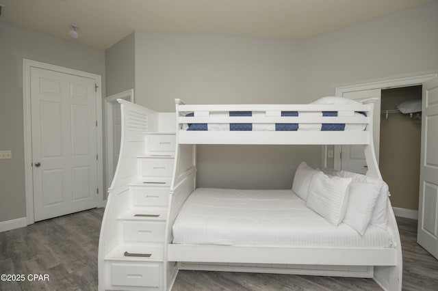 bedroom with baseboards and wood finished floors