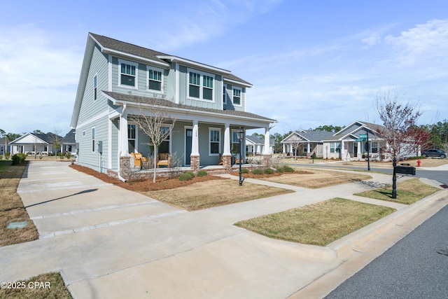 view of front of home featuring a porch, a residential view, and driveway