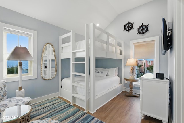 bedroom featuring vaulted ceiling, wood finished floors, and baseboards