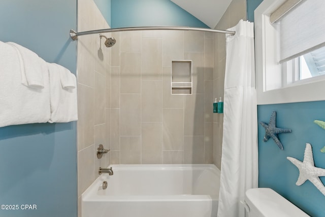 bathroom featuring toilet and shower / bath combination with curtain