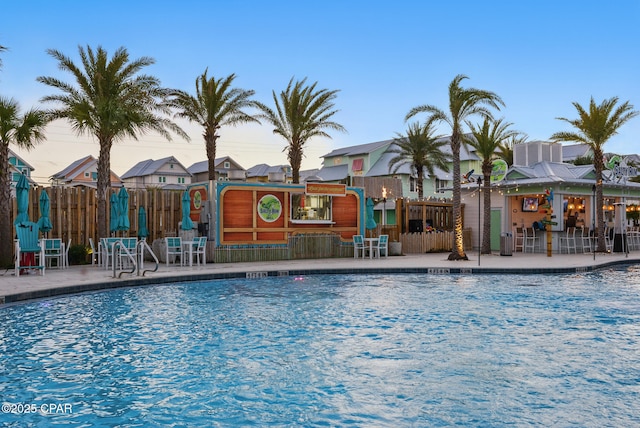 pool with a patio area, a residential view, and fence