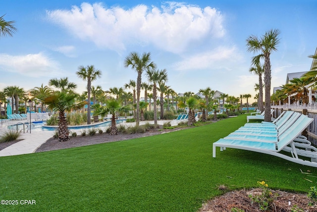 view of property's community with a swimming pool, a lawn, and fence