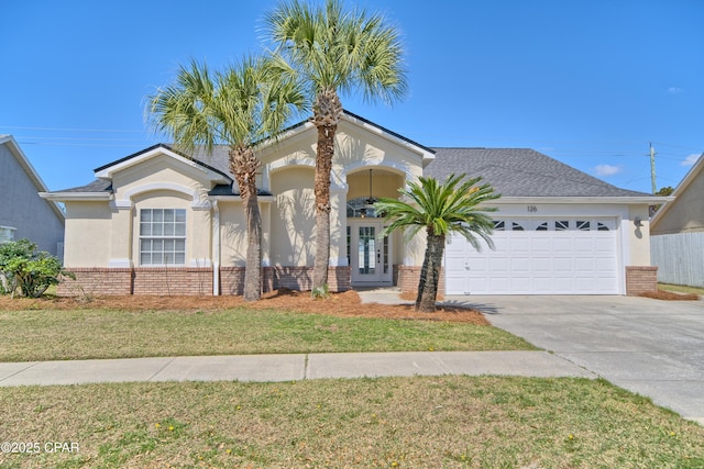 view of front of property featuring stucco siding, brick siding, a garage, and concrete driveway