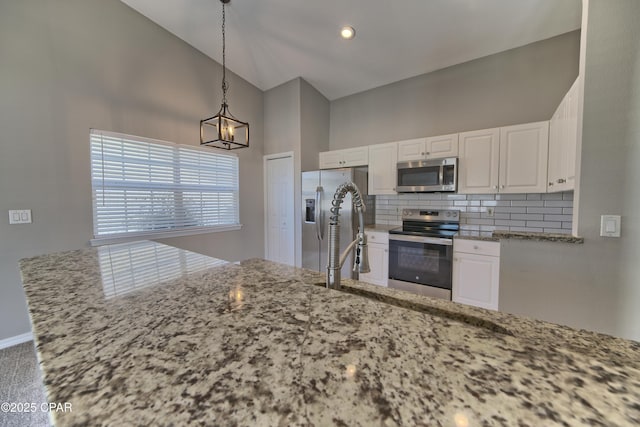 kitchen featuring backsplash, white cabinetry, light stone countertops, appliances with stainless steel finishes, and high vaulted ceiling