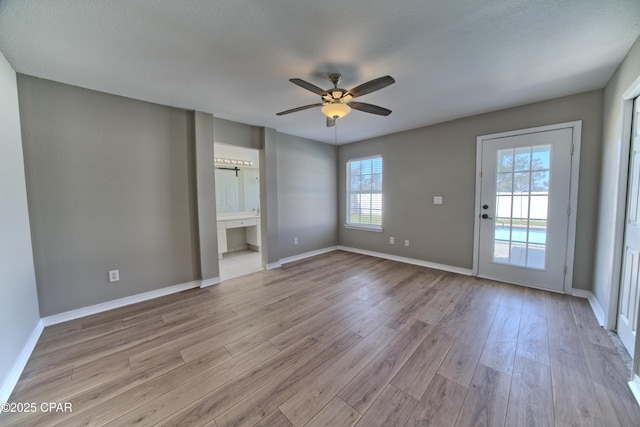 unfurnished room with light wood-style flooring, baseboards, and a ceiling fan