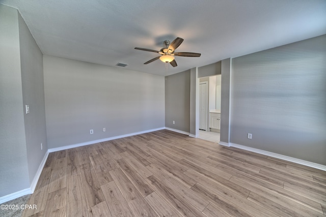 spare room featuring visible vents, light wood-style flooring, baseboards, and a ceiling fan