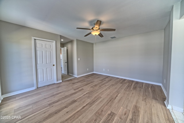 interior space featuring visible vents, ceiling fan, light wood-type flooring, and baseboards