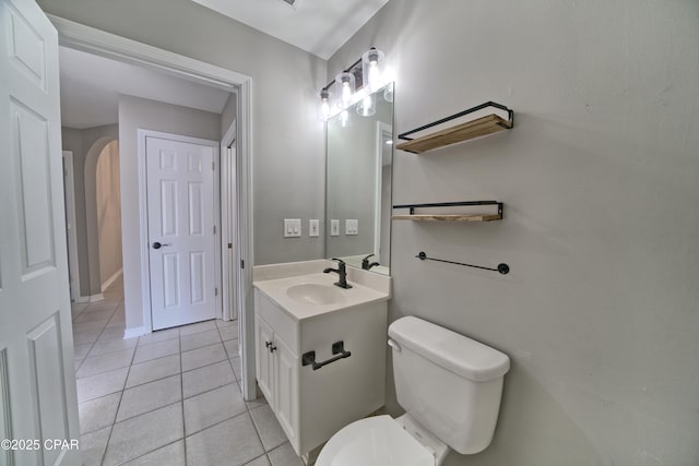 half bathroom with baseboards, toilet, vanity, and tile patterned flooring