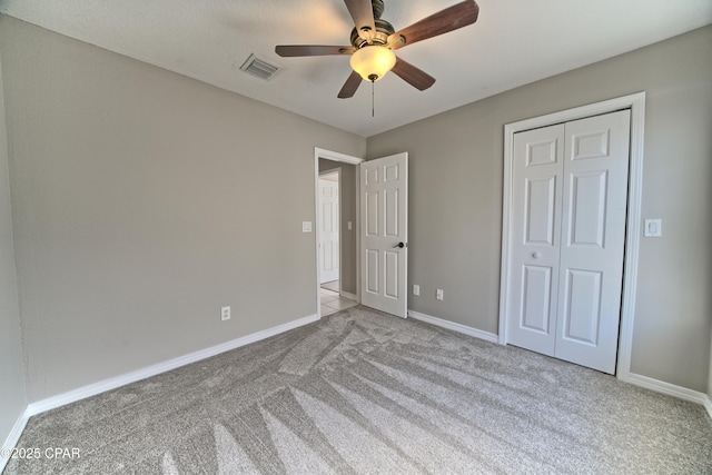 unfurnished bedroom with a closet, visible vents, baseboards, and carpet floors