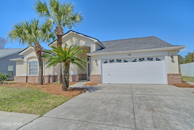 single story home featuring brick siding, stucco siding, concrete driveway, and a garage