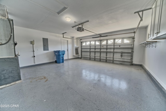 garage with electric panel, a garage door opener, and baseboards