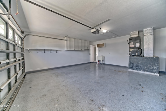 garage with heating unit, a garage door opener, baseboards, and a sink