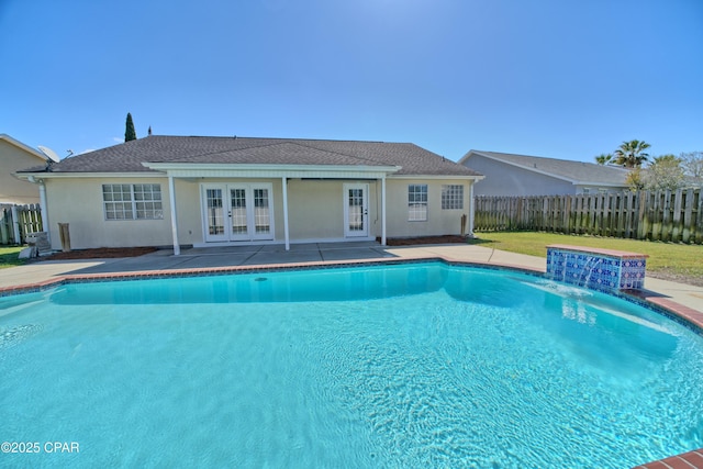 view of swimming pool with french doors, a patio, a fenced in pool, and fence