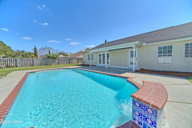 view of swimming pool with a patio area, french doors, a fenced in pool, and a fenced backyard