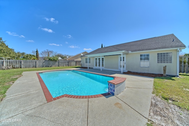 view of swimming pool with a fenced in pool, a lawn, french doors, a fenced backyard, and a patio area