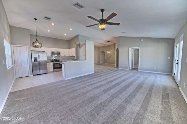 kitchen featuring visible vents, light carpet, a ceiling fan, decorative light fixtures, and stainless steel appliances