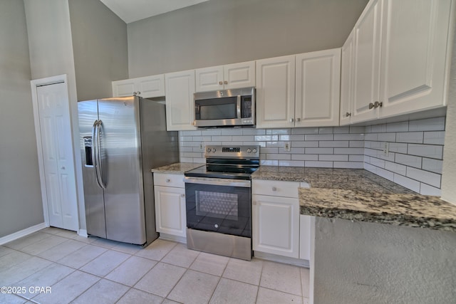 kitchen featuring light tile patterned floors, white cabinets, appliances with stainless steel finishes, and tasteful backsplash