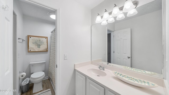 full bath with vanity, toilet, and wood finished floors