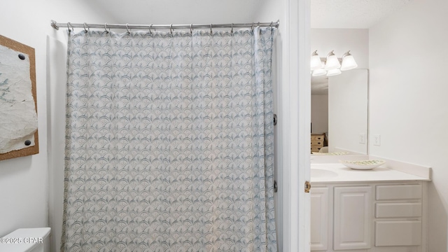 bathroom featuring curtained shower, toilet, and vanity