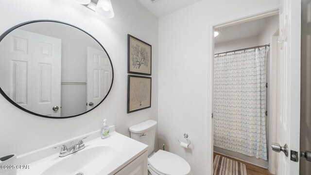 bathroom with a shower with shower curtain, toilet, and vanity