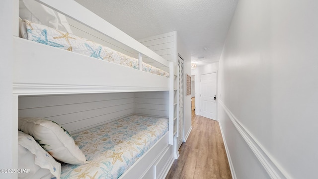 bedroom with a textured ceiling and wood finished floors