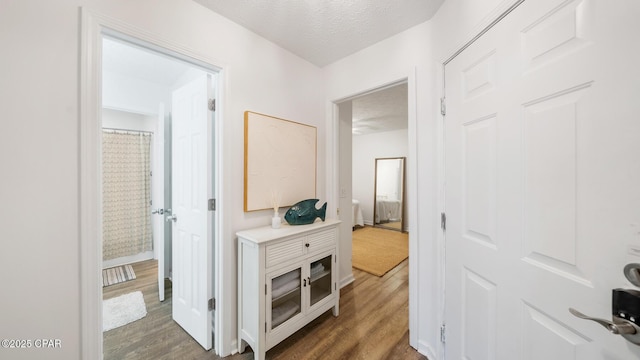 hall featuring a textured ceiling and wood finished floors