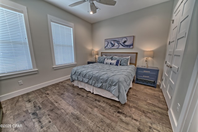 bedroom featuring baseboards, wood finished floors, and a ceiling fan