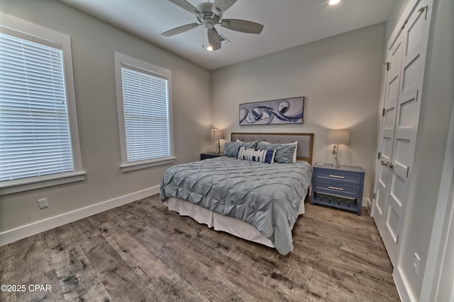 bedroom with ceiling fan, baseboards, and wood finished floors