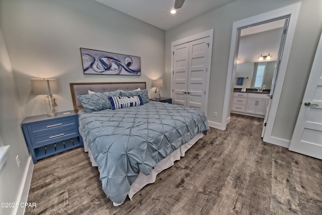 bedroom featuring connected bathroom, baseboards, a closet, and wood finished floors