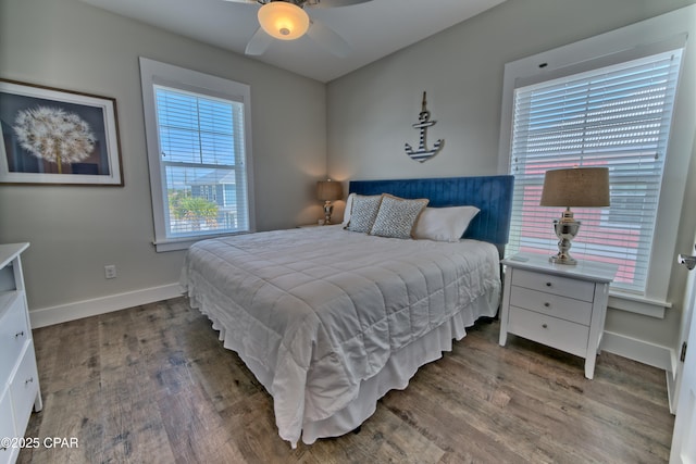 bedroom with ceiling fan, baseboards, and wood finished floors