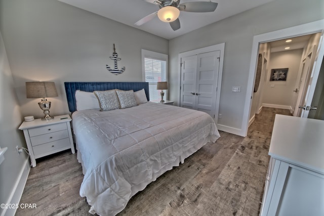 bedroom with a closet, ceiling fan, baseboards, and wood finished floors