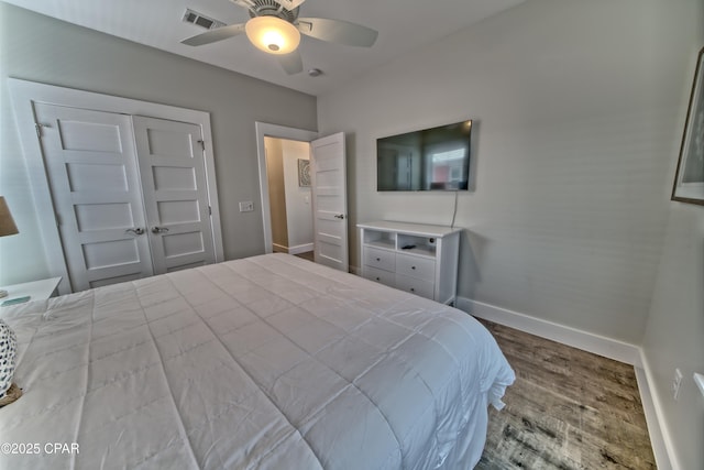 bedroom with visible vents, baseboards, wood finished floors, and a ceiling fan