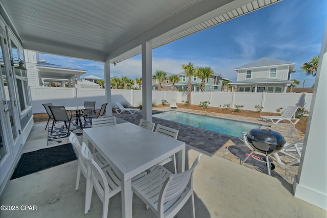 view of patio with a fenced in pool, a fenced backyard, a grill, and outdoor dining space