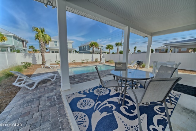 view of patio / terrace featuring outdoor dining space, a fenced in pool, and a fenced backyard