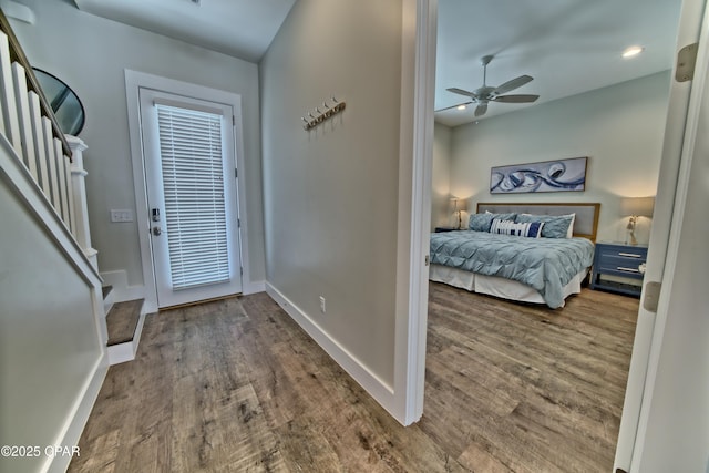 entryway with a ceiling fan, wood finished floors, baseboards, recessed lighting, and stairs