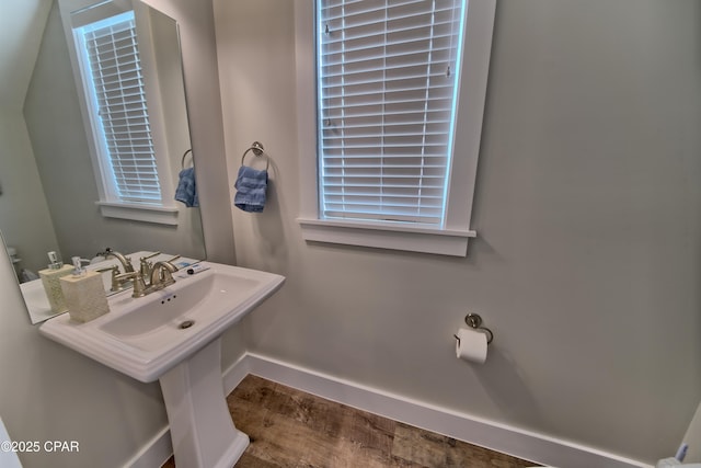 bathroom with a sink, baseboards, and wood finished floors