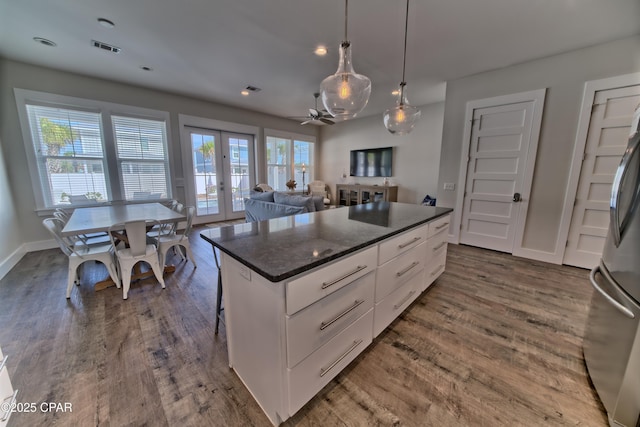 kitchen with visible vents, dark wood-style floors, freestanding refrigerator, french doors, and white cabinets