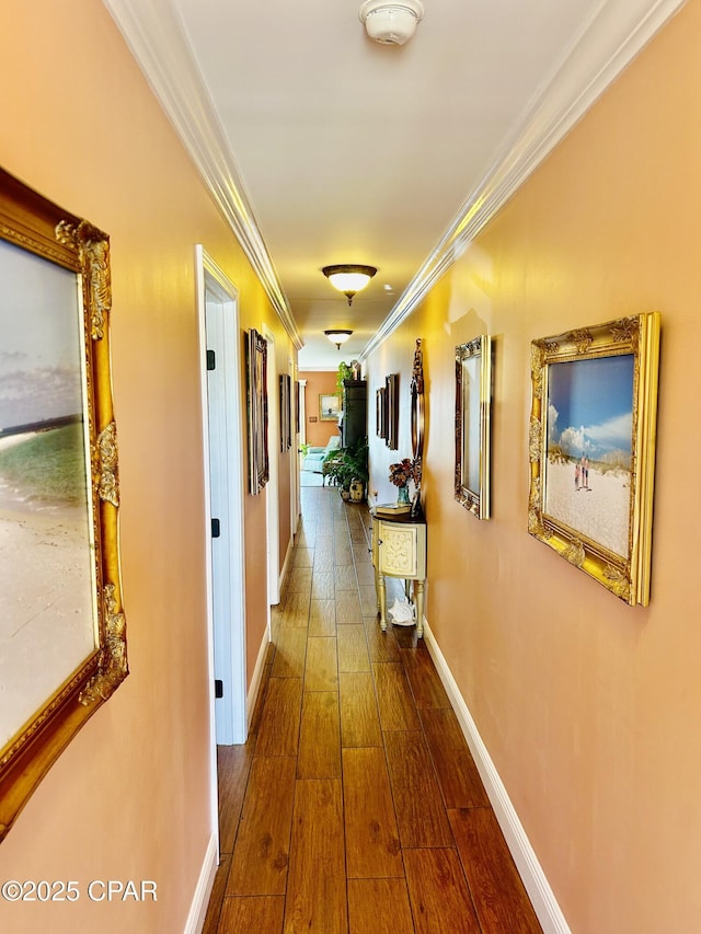 hall with dark wood-style floors, baseboards, and ornamental molding