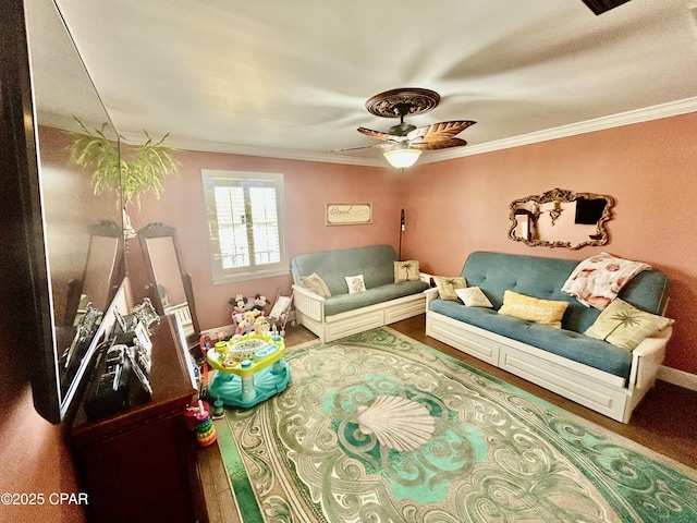 living area with baseboards, crown molding, a ceiling fan, and wood finished floors