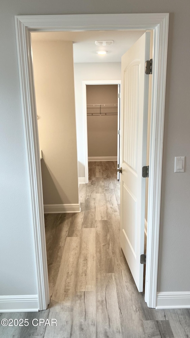 hallway with baseboards and wood finished floors