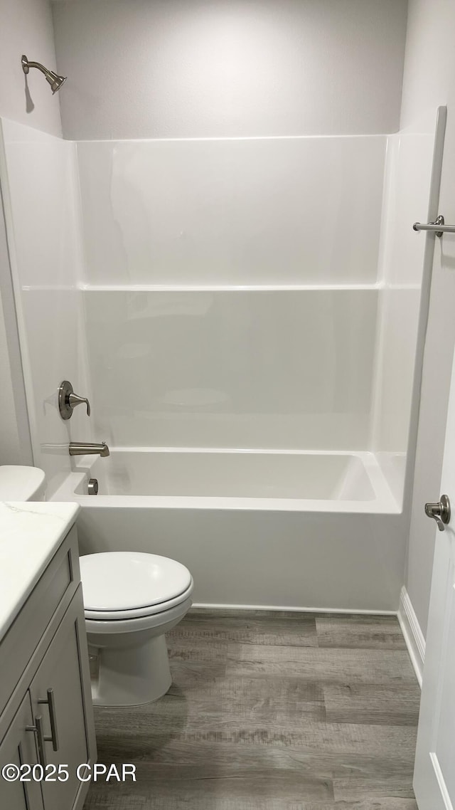 bathroom with vanity, bathing tub / shower combination, toilet, and wood finished floors