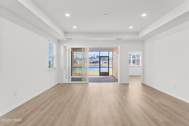 spare room featuring recessed lighting, light wood-style floors, and baseboards