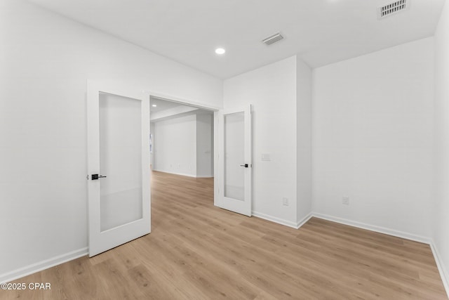 empty room featuring visible vents, recessed lighting, light wood-type flooring, and baseboards