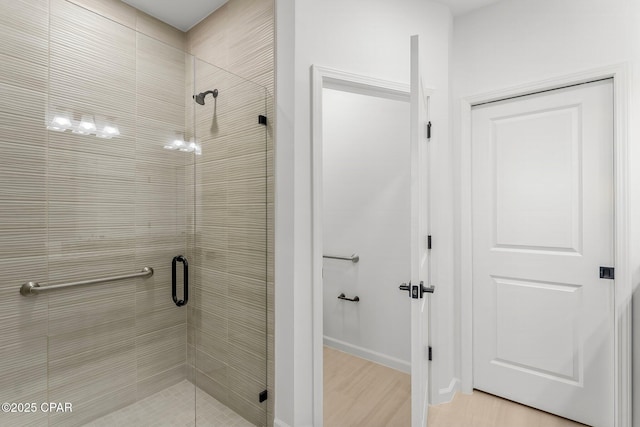 full bathroom with wood finished floors and a shower stall