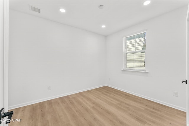 spare room with recessed lighting, light wood-style floors, and baseboards