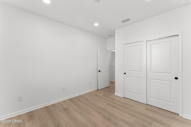 unfurnished bedroom with visible vents, light wood-style flooring, recessed lighting, a closet, and baseboards